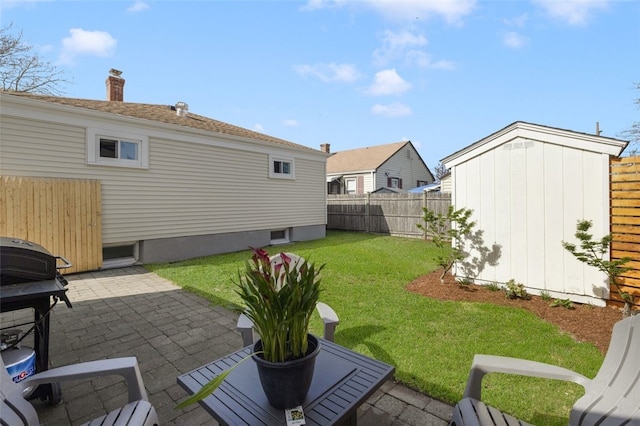 view of yard featuring an outdoor structure, a patio, a shed, and a fenced backyard