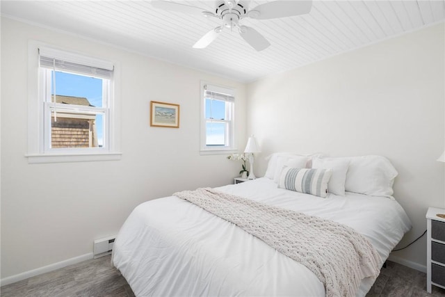 bedroom featuring baseboards, a baseboard radiator, a ceiling fan, and wood finished floors