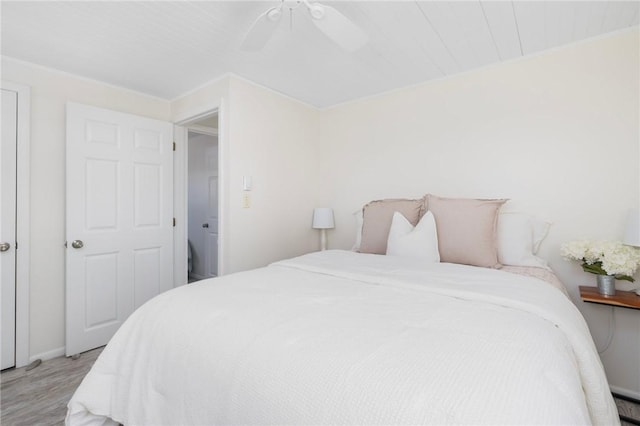 bedroom featuring a ceiling fan, baseboards, and wood finished floors