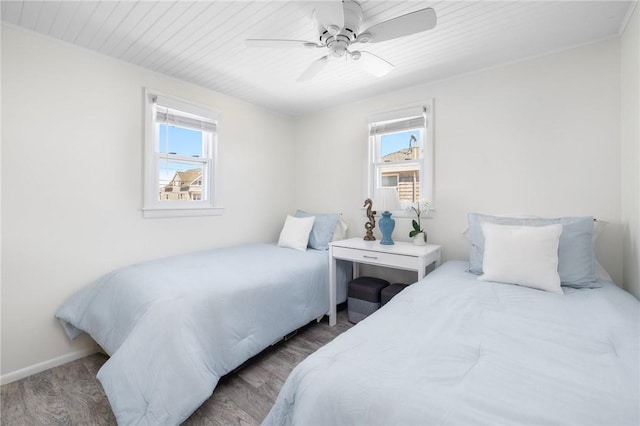 bedroom featuring wood ceiling, baseboards, multiple windows, and wood finished floors