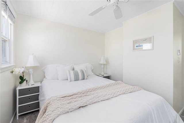 bedroom featuring a ceiling fan, baseboards, and wood finished floors
