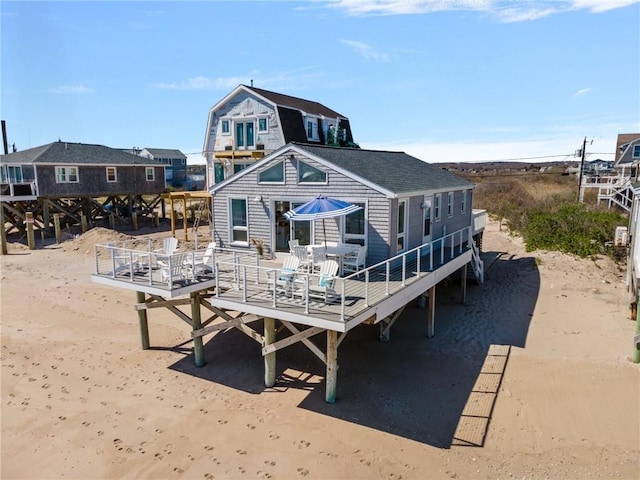 rear view of house with a wooden deck and a gambrel roof