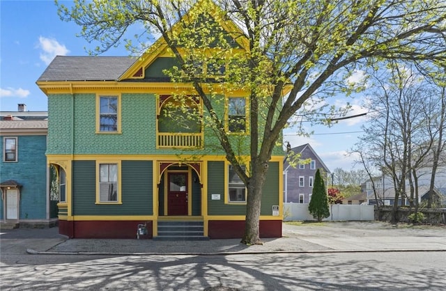 victorian home with fence and a balcony