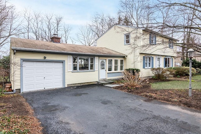 180 Birkshire Dr, Warwick, RI 02886 - view of front of home with an attached garage, a chimney, and aphalt driveway