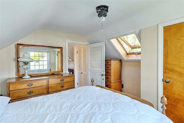 bedroom with ceiling fan and vaulted ceiling with skylight