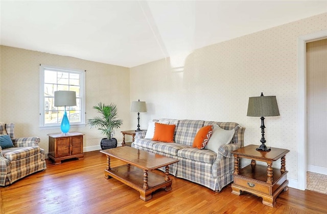 living room with baseboards, wood finished floors, and wallpapered walls