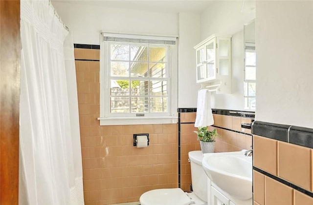 full bathroom featuring wainscoting, tile walls, vanity, and toilet