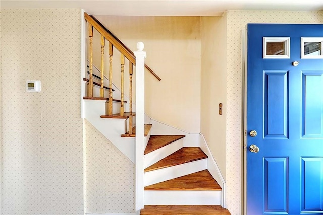 stairs featuring wallpapered walls