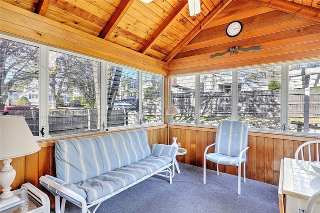 sunroom with vaulted ceiling with beams, carpet flooring, wooden walls, and wooden ceiling