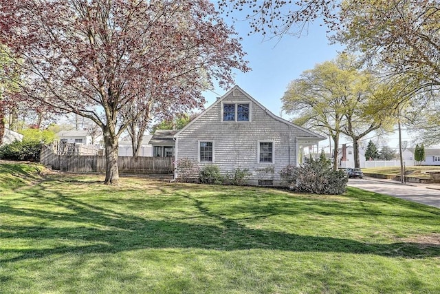 view of property exterior featuring a lawn and fence