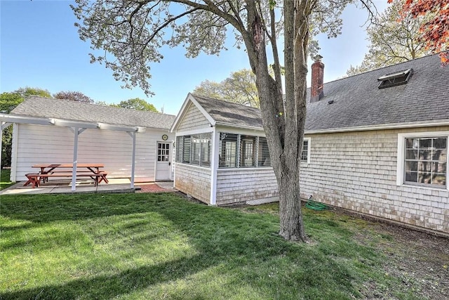 back of property featuring a lawn, a pergola, a chimney, and a sunroom