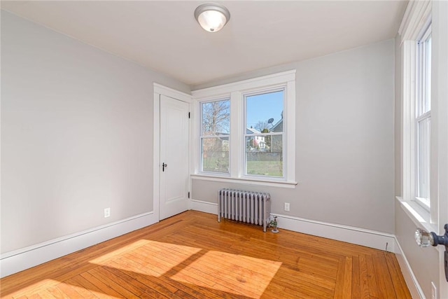 888 Providence St, West Warwick, RI 02893 - spare room with baseboards, radiator, wood finished floors, and a wealth of natural light