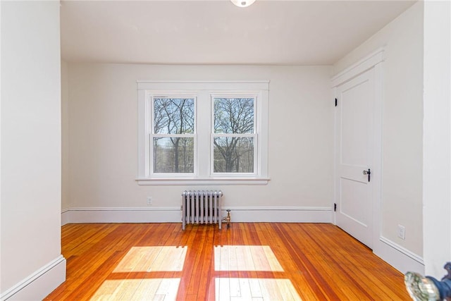 888 Providence St, West Warwick, RI 02893 - empty room featuring radiator heating unit, baseboards, and hardwood / wood-style flooring