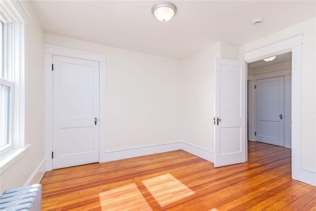 888 Providence St, West Warwick, RI 02893 - empty room featuring radiator heating unit, baseboards, and light wood finished floors