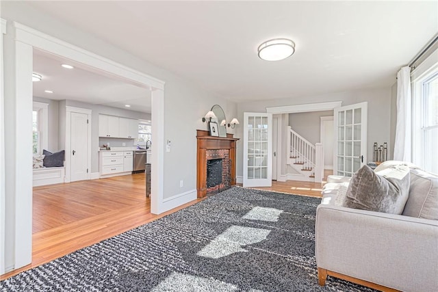 888 Providence St, West Warwick, RI 02893 - living room featuring light wood-type flooring, stairs, and a fireplace