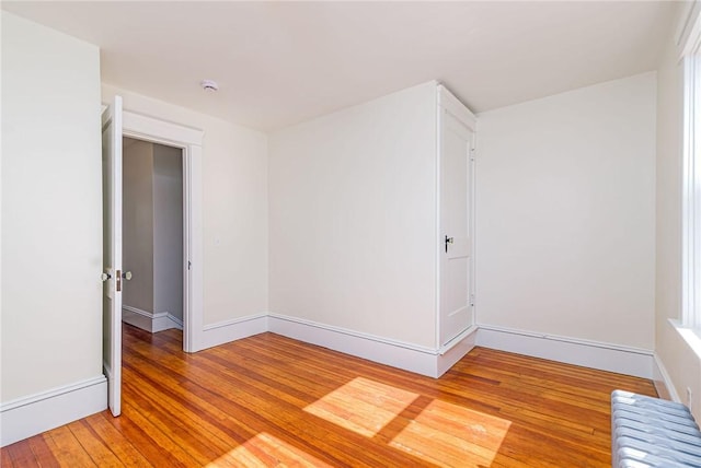 888 Providence St, West Warwick, RI 02893 - spare room with baseboards, light wood-style flooring, and radiator heating unit