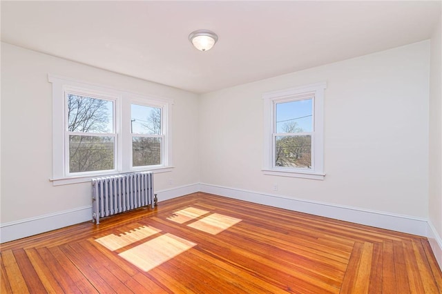 888 Providence St, West Warwick, RI 02893 - empty room with baseboards, plenty of natural light, radiator heating unit, and wood finished floors