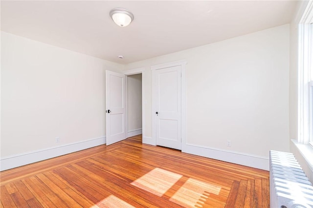 888 Providence St, West Warwick, RI 02893 - spare room featuring baseboards, radiator heating unit, and wood finished floors