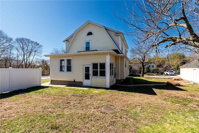 888 Providence St, West Warwick, RI 02893 - rear view of house with a lawn, a gambrel roof, and fence