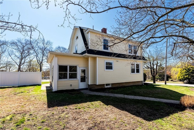 888 Providence St, West Warwick, RI 02893 - rear view of property featuring fence, a chimney, a yard, and a gambrel roof