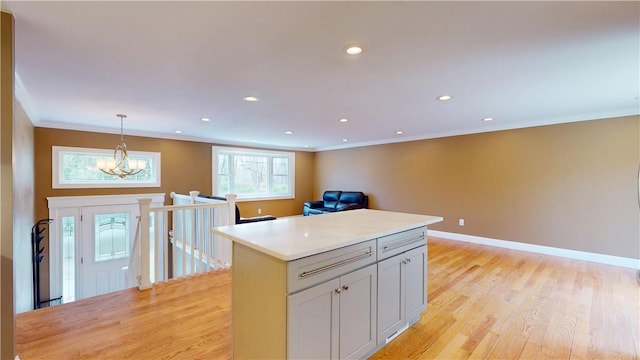 108 Shady Lea Rd, North Kingstown, RI 02852 - kitchen featuring crown molding, light wood finished floors, a kitchen island, and a notable chandelier