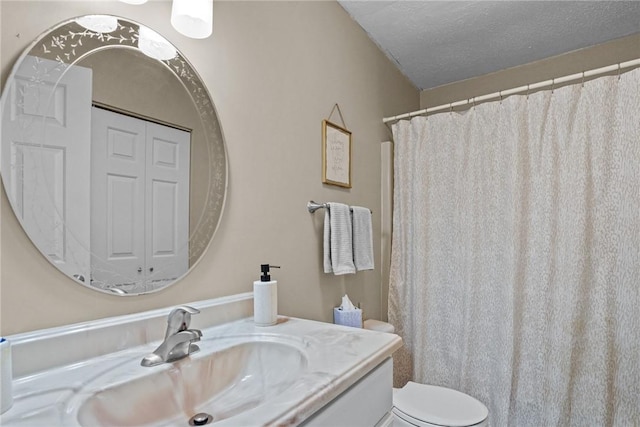 full bathroom with vanity, toilet, and a textured ceiling