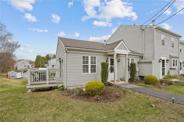 view of front of property featuring a wooden deck and a front lawn