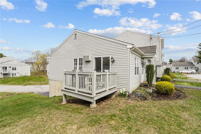 back of property with a yard and a deck