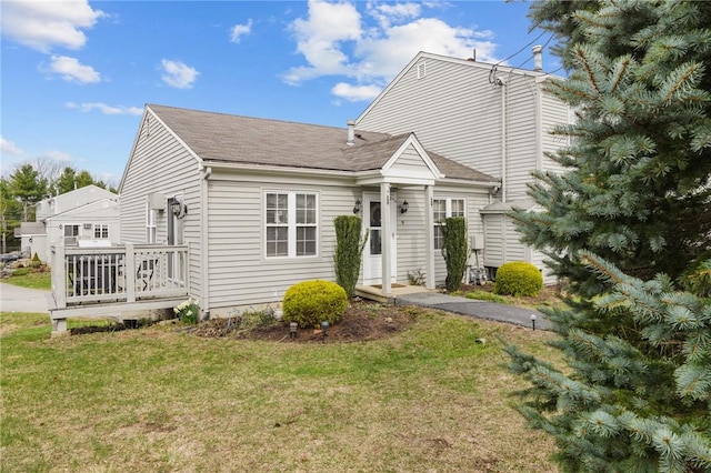 view of front of property featuring roof with shingles and a front yard