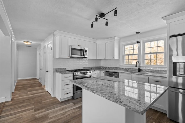 87 Elmbrook Dr, Warwick, RI 02889 - kitchen with dark wood-style flooring, a sink, a textured ceiling, and appliances with stainless steel finishes