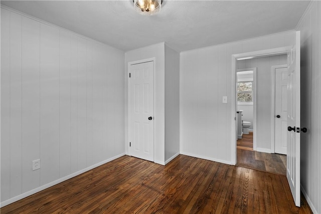 87 Elmbrook Dr, Warwick, RI 02889 - unfurnished bedroom with baseboards, ornamental molding, a closet, and dark wood-type flooring
