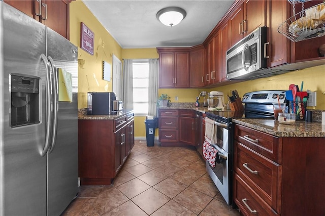 70 Perkins Ave, Cranston, RI 02910 - kitchen featuring appliances with stainless steel finishes, tile patterned flooring, dark stone countertops, and reddish brown cabinets