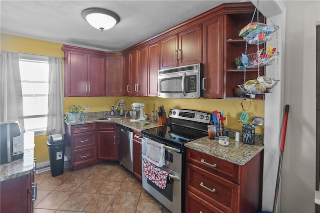 70 Perkins Ave, Cranston, RI 02910 - kitchen featuring a sink, light stone counters, light tile patterned floors, reddish brown cabinets, and stainless steel appliances