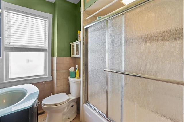 70 Perkins Ave, Cranston, RI 02910 - full bathroom featuring vanity, toilet, tile walls, bath / shower combo with glass door, and a wainscoted wall