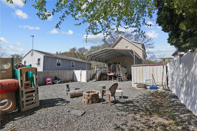 70 Perkins Ave, Cranston, RI 02910 - exterior space featuring a storage shed, a carport, an outdoor structure, a fenced backyard, and an outdoor fire pit