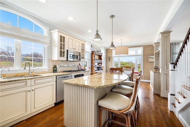 244 Spring St, Block Island, RI 02807 - kitchen featuring a kitchen island, light stone countertops, dark wood-style floors, a sink, and appliances with stainless steel finishes