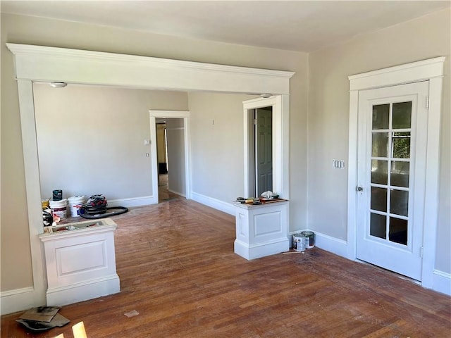 interior space with baseboards and wood finished floors