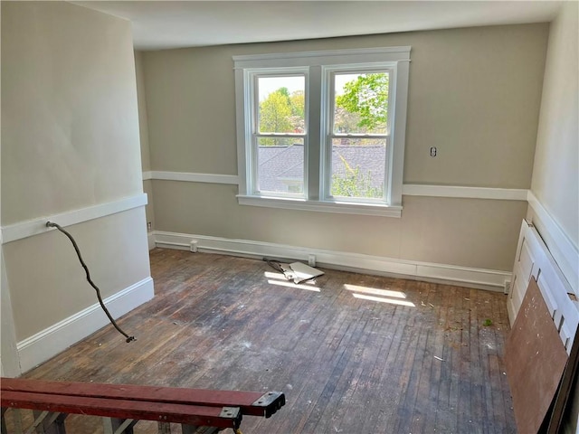 unfurnished room featuring wood-type flooring and baseboards