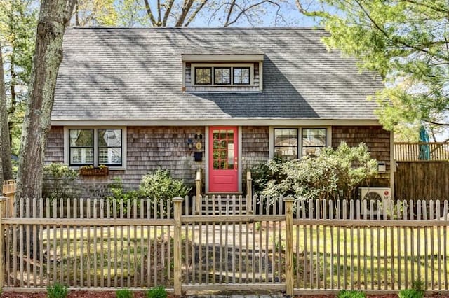 view of front of house featuring a shingled roof and fence private yard