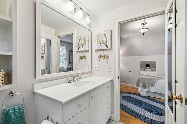 ensuite bathroom with vanity, wood finished floors, and connected bathroom