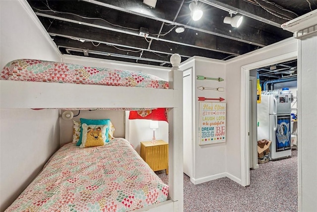 bedroom featuring freestanding refrigerator, baseboards, and carpet