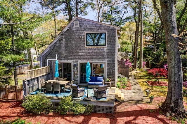 back of property with fence, outdoor dining area, and outdoor lounge area