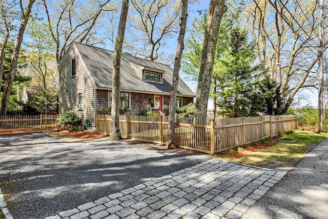 view of front facade featuring a fenced front yard and a shingled roof