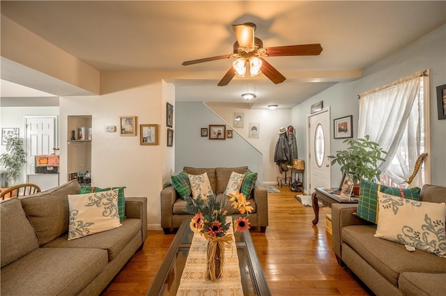 living area featuring baseboards, light wood-style flooring, and ceiling fan