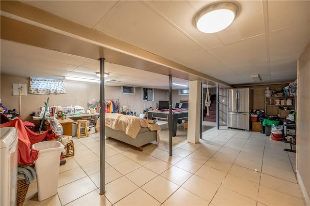 finished below grade area featuring tile patterned floors, freestanding refrigerator, and pool table