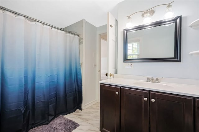 full bath with a shower with curtain, marble finish floor, and vanity