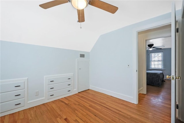 additional living space featuring baseboards, ceiling fan, wood finished floors, and lofted ceiling