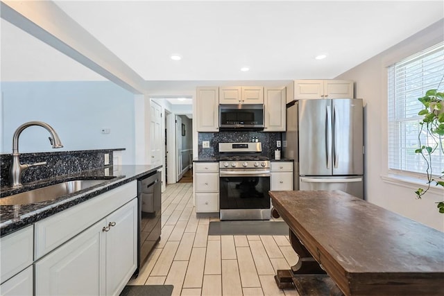 kitchen featuring a sink, plenty of natural light, backsplash, and stainless steel appliances