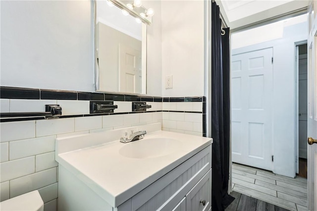 bathroom with vanity, tile walls, and wood finished floors