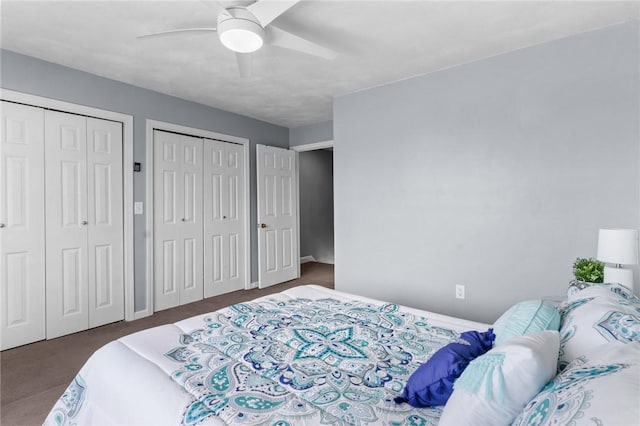 carpeted bedroom featuring a ceiling fan and multiple closets